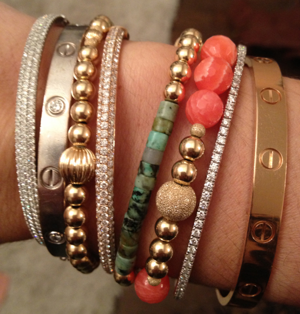 An arm party featuring Cartier Love Bracelets