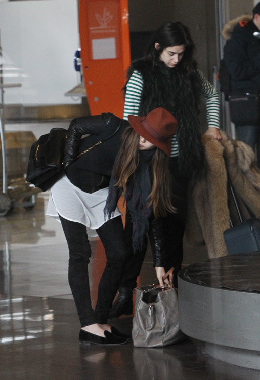 Elizabeth Olsen carries a black Alexander McQueen Heroine Shoulder Bag and a large Chanel tote at the airport in Paris. (1)