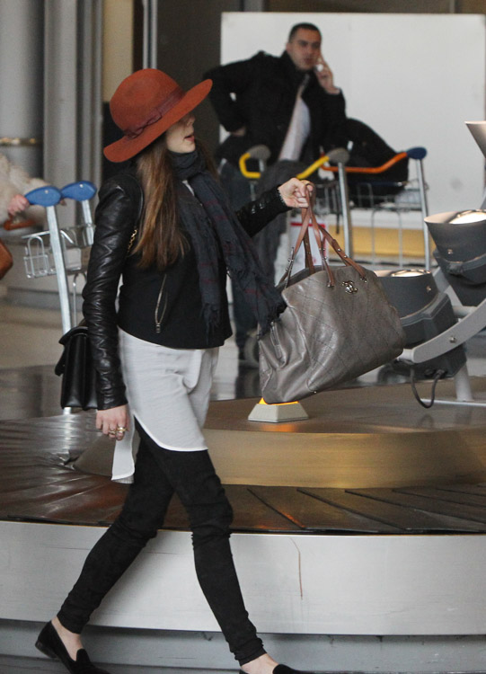 Elizabeth Olsen carries a black Alexander McQueen Heroine Shoulder Bag and a large Chanel tote at the airport in Paris. (3)