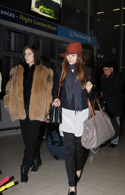 Elizabeth Olsen carries a black Alexander McQueen Heroine Shoulder Bag and a large Chanel tote at the airport in Paris. (4)