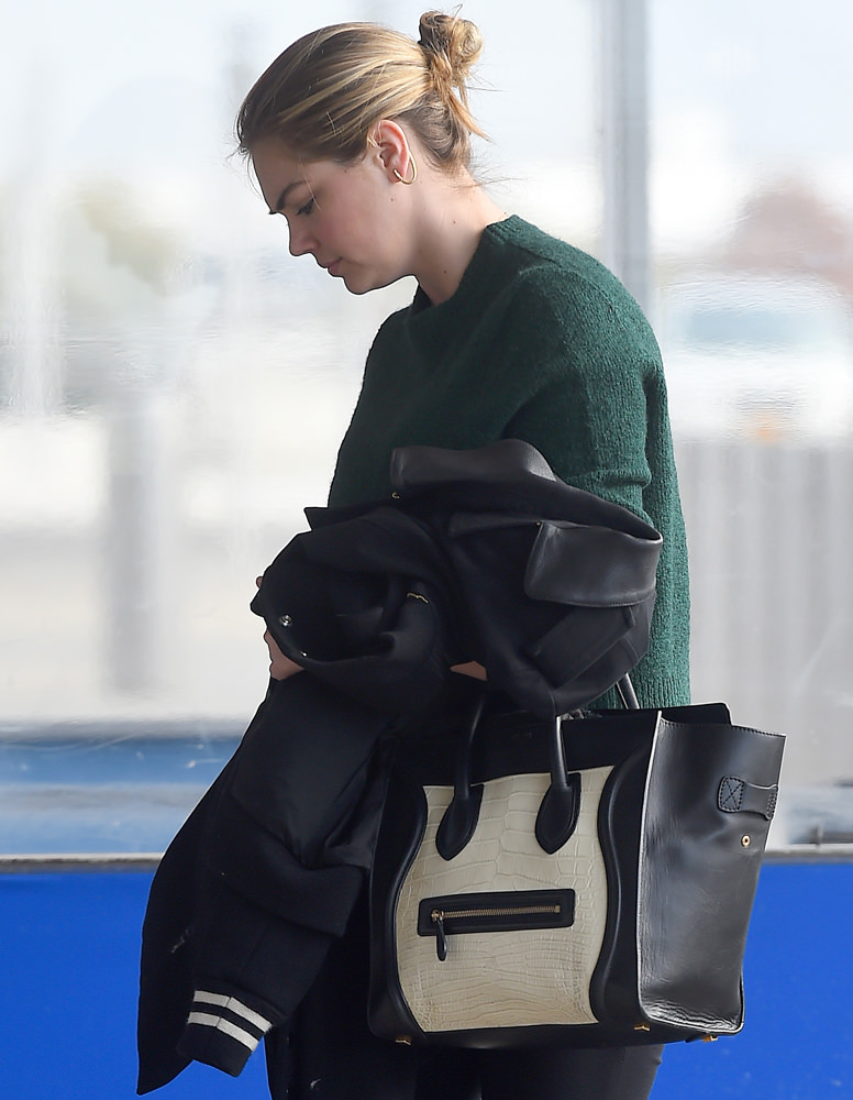 A make up free Kate Upton holds on to her Celine handbag while leaving JFK airport in Queens, New York