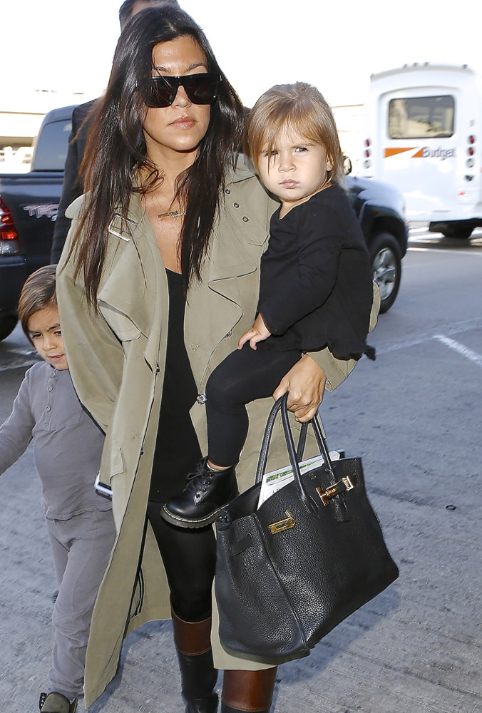 Reality star Kourtney Kardashian and kids were seen departing LAX for Kim's wedding