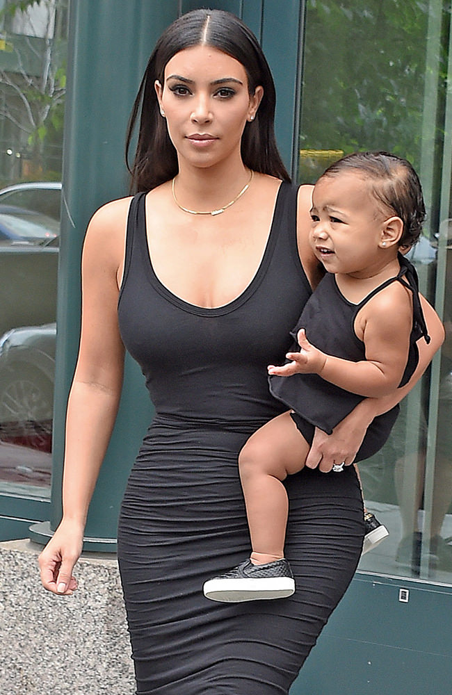 Kim Kardashian carries her baby North as they step out in matching black outfits leaving their SoHo apartment in NYC