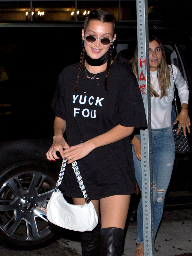 bella hadid carries her louis vuitton and chanel bags as she steps