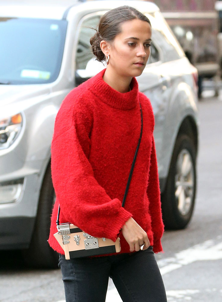 alicia vikander carries a large louis vuitton bag as she arrives