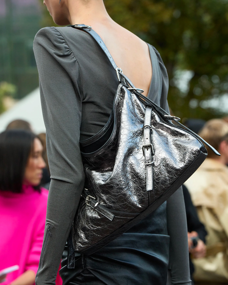 A guest is seen wearing a white sweater dress, Chanel heart bag