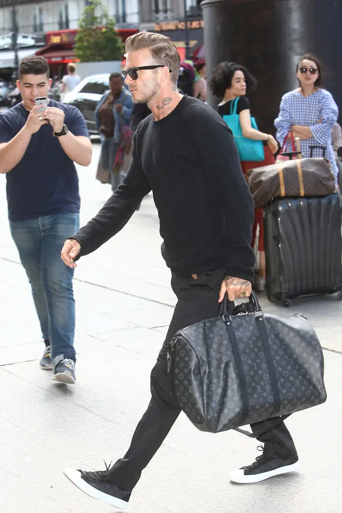 David Beckham, carrying his Louis Vuitton travel bag, gets a