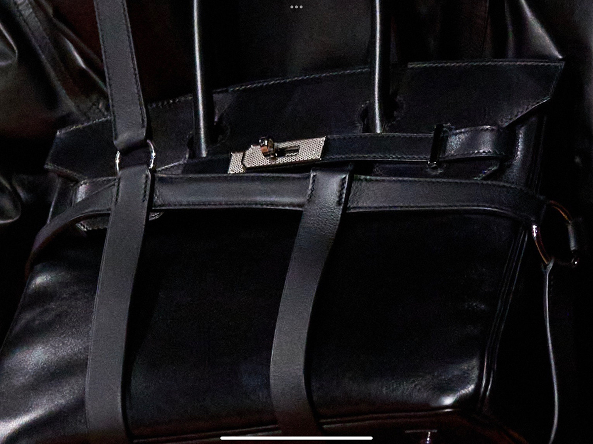 A close-up of the Birkin in the harness, which was worn over the shoulder in Look 46, reveals a surprising detail -the return of Guilloche hardware. Photo via Vogue.com