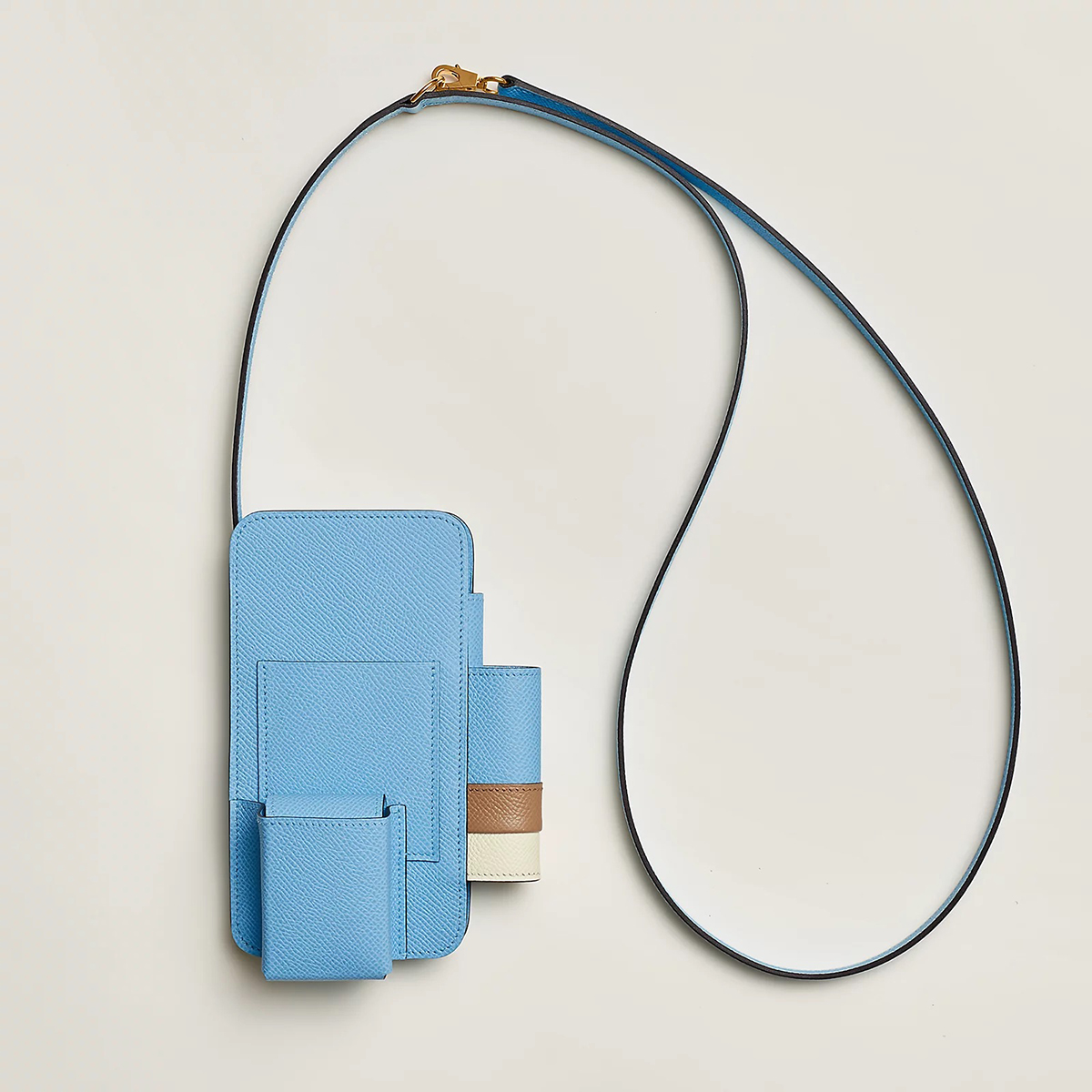 The Hermèsway Phone Case features a phone pouch, card slot, AirPods case, and lipstick holder. Hermèsway in Celeste/Chai/Nata. Photo via Hermes.com.