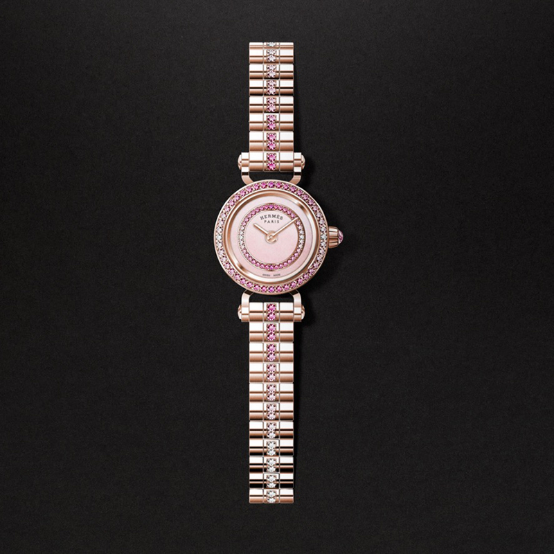 Faubourg watch, Mini model, 15 mm, gem-set rose opal dial, 14 diamonds (0.04 ct) and 31 pink sapphires (0.121 ct), gem-set single tour rose gold bracelet, 98 diamonds (0.382 ct), 34 pink sapphires (1.462 ct), $24,525. Photo via Hermès.com.