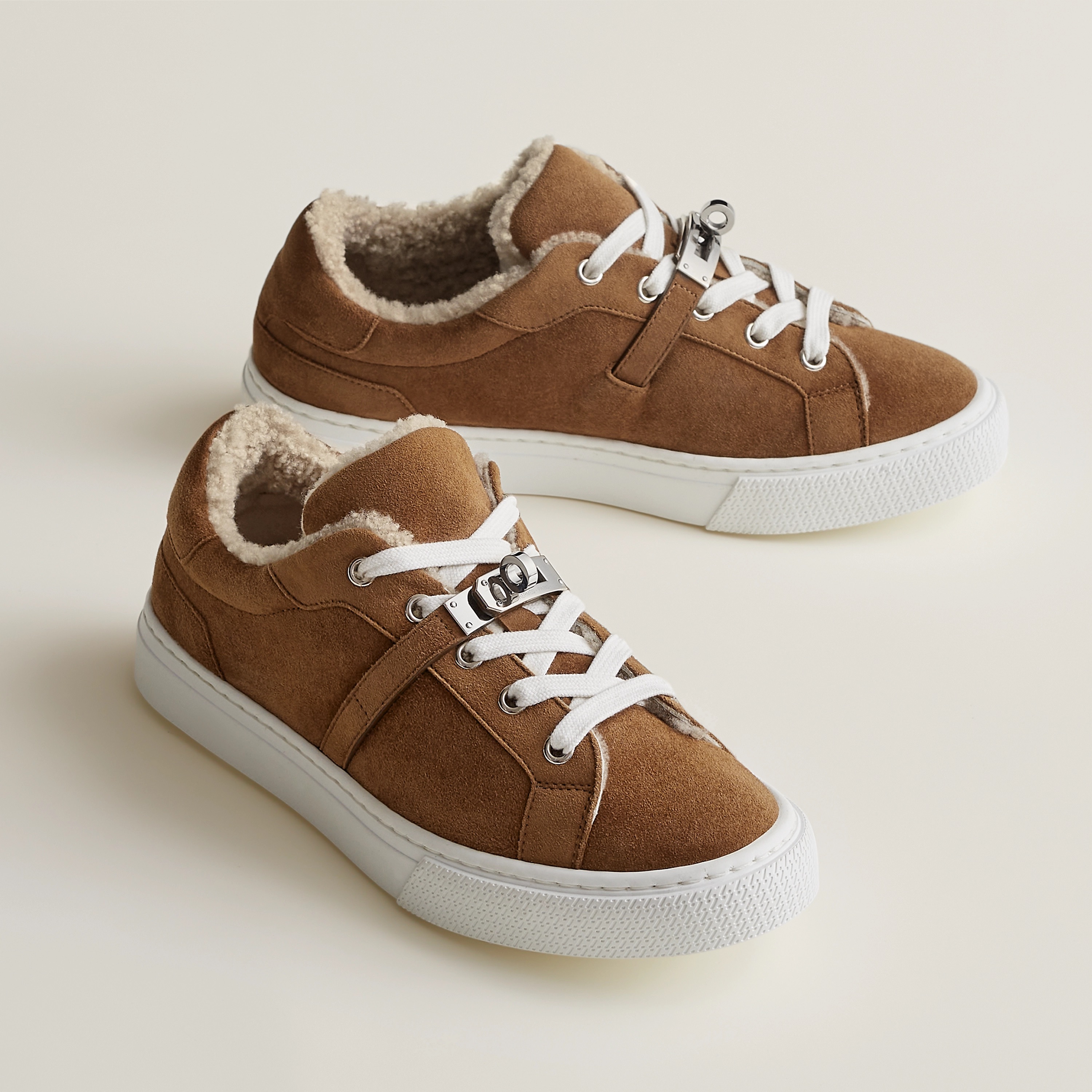 Brun Fumé / Écru Day Sneaker in suede goatskin with shearling lining and functional palladium-plated Kelly buckle, $1350. Photo via Hermès.com.