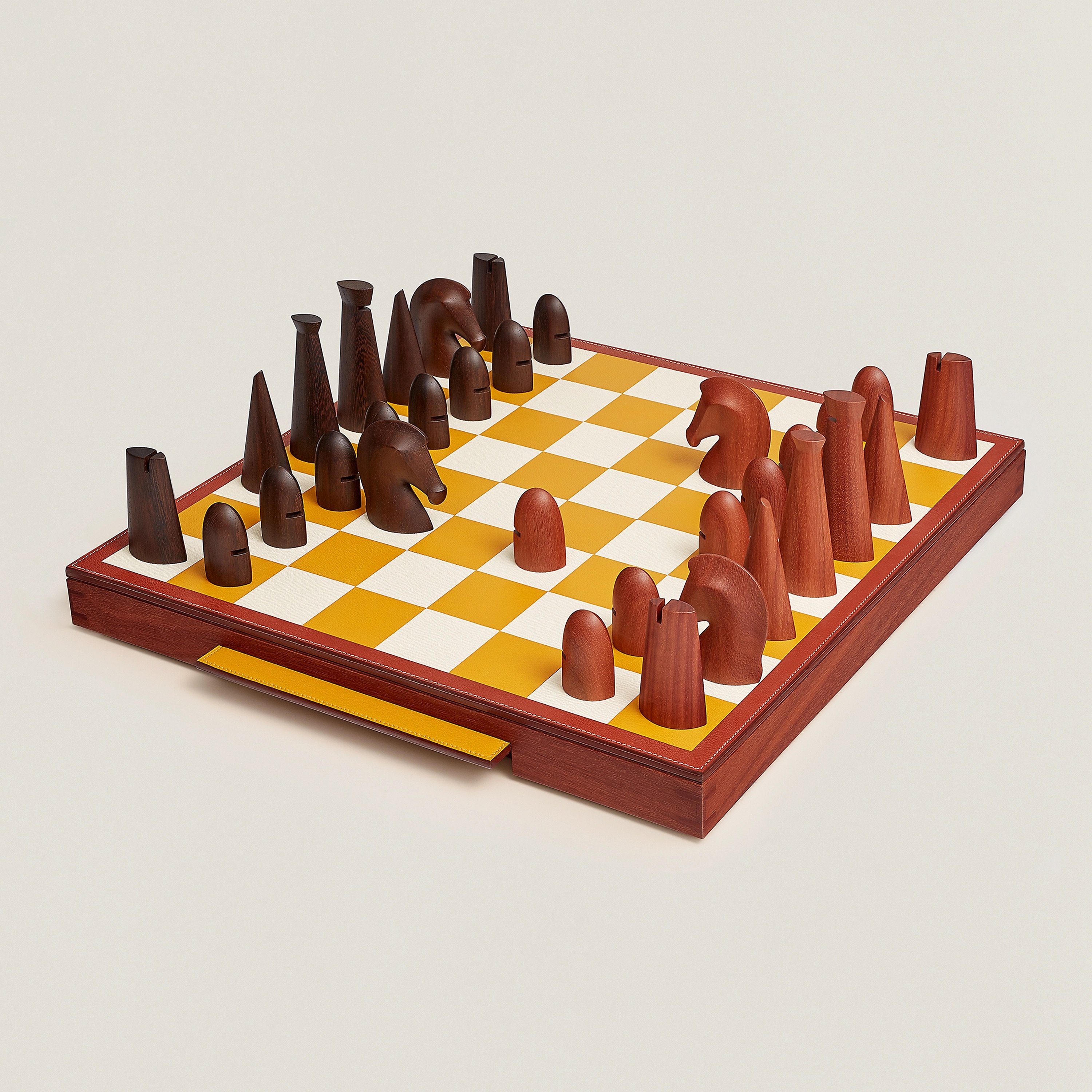 Samarcande Chess set in sapodilla wood and leather marquetry, hand sculpted pawns in solid cassia and sapodilla wood with Clou de Selle engraved stainless steel weights. Handles in saddle-stitched Evercolor calfskin. Leather marquetry. $15,700. Photo via Hermès.com